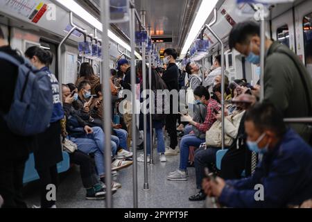 A busy subway in China featuring numerous passengers wearing protective face masks Stock Photo