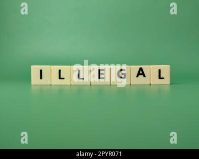 Toys word with the word ILLEGAL on a green background Stock Photo