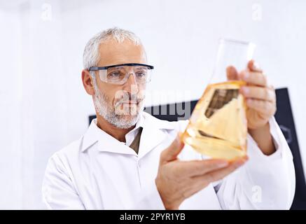 Making advances in the field of science. a mature male scientist examining the results of an experiment in his lab. Stock Photo