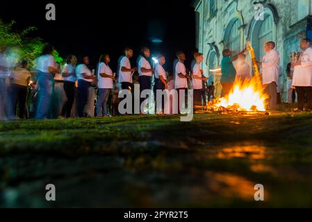 Valenca, Bahia, Brazil - April 08, 2023: Catholics are around the holy bonfire, on the hallelujah Saturday night, to light their candles. Holy week in Stock Photo