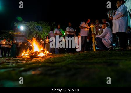 Valenca, Bahia, Brazil - April 08, 2023: Catholics are around the holy bonfire, on the hallelujah Saturday night, to light their candles. Holy week in Stock Photo