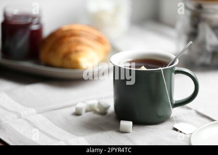 Cup of freshly brewed tea and sugar cubes on table Stock Photo