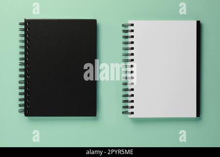 Two notebooks on turquoise background, flat lay Stock Photo