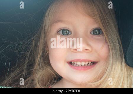 Portrait of a cute Caucasian blonde child with blue eyes. Blue-eyed kid. Close up face of a child in a hat Stock Photo