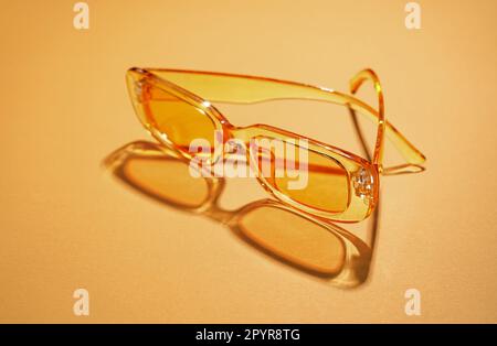 Modern sunglasses on orange background Stock Photo