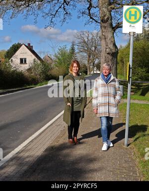 Millienhagen, Germany. 03rd May, 2023. Maria S. Kasten (l-r) and Diana Nurkewitz stand at the bus stop in the village where the children get on every morning at 6:12 a.m. and get off at 4:40 p.m. who have to go to the high school in Grimmen. The children spend three hours on buses every day. The mothers are fighting in a parents' initiative for shorter commute times. Credit: Bernd Wüstneck/dpa/Alamy Live News Stock Photo