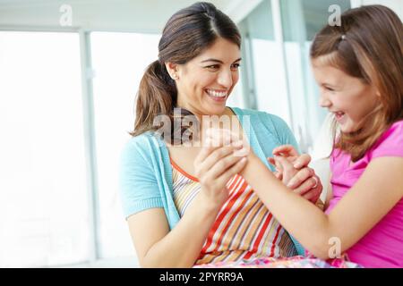 Spending the afternoon together. A cute young girl holding hands with her mother and laughing playfully. Stock Photo