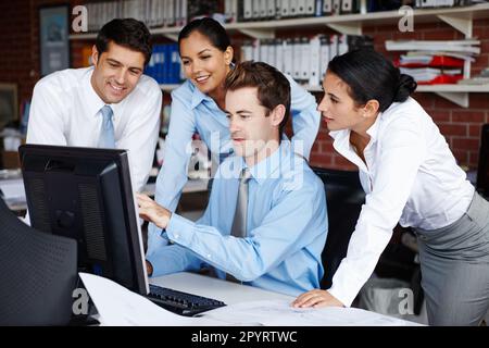 Getting some help from his colleagues. A young business team collaborating on a project together. Stock Photo