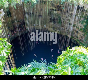 People swimming in limestone sinkhole pool, Cenote Ik kil, Pisté, Yucatan, Mexico Stock Photo