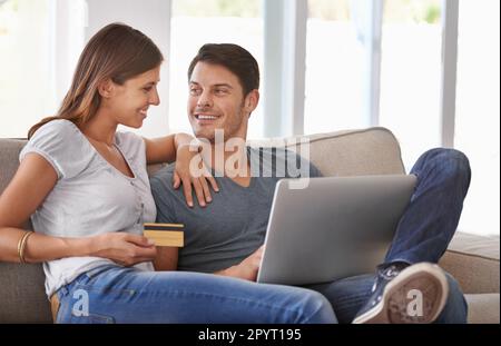 Online shopping at home. An affectionate young couple doing some online shopping at home. Stock Photo