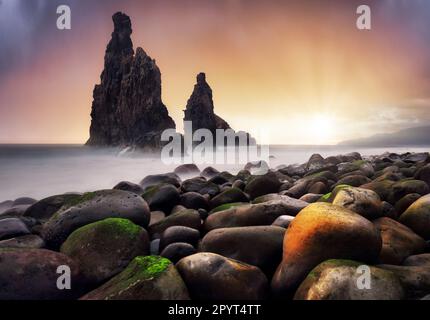 Beautiful scenery seascape of Atlantic ocean. Stunning summer sunrise on Ilheu da Ribeira da Janela rock formation. Colorful summer scene of Madeira, Stock Photo