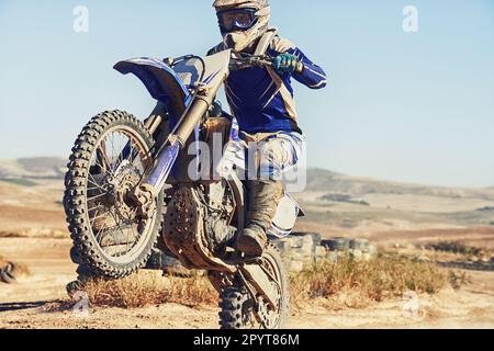 Hes in full control. a motocross driver performing a wheelie during a race. Stock Photo
