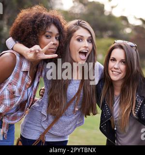 Its great having people you can be crazy with. a group of girlfriends posing for a silly photo. Stock Photo