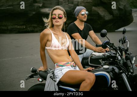 Stylish couple on motorcycles on the ocean beach. Bali. Stock Photo