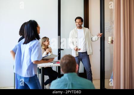 Happy male entrepreneur discussing with colleagues standing at cafe Stock Photo