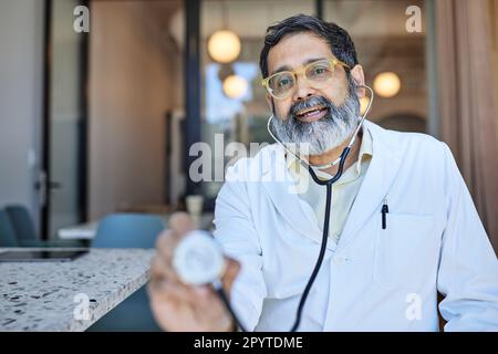 Portrait of male doctor holding stethoscope in clinic Stock Photo
