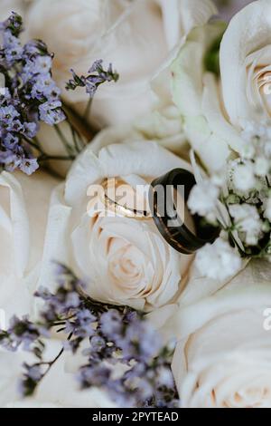 Gold and black wedding rings in bouquet Stock Photo