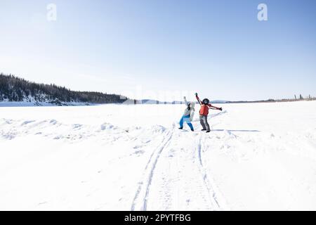 Two happy people on the frozen Yukon River in Alaska Stock Photo