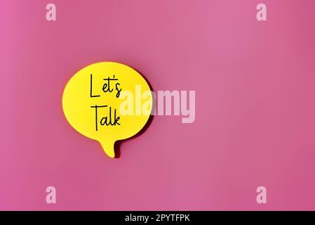 Top view image of speech bubble with text LET'S TALK on pink background with copy space. Stock Photo