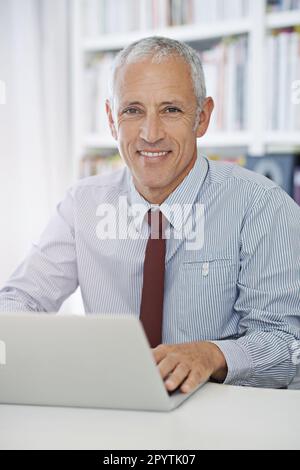 Growing is business online. Portrait of a mature businessman working on a laptop. Stock Photo