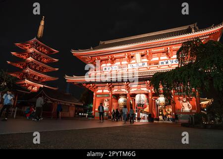 TOKYO, JAPAN - APRIL 7, 2023: People walking around Senso-ji temple in Asakusa area in the evening with rain drizzle Stock Photo
