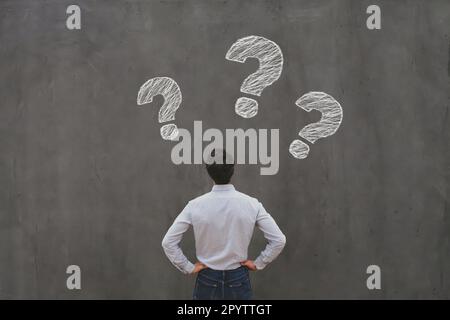 questions, business man looking at interrogation marks, why what where when how who Stock Photo