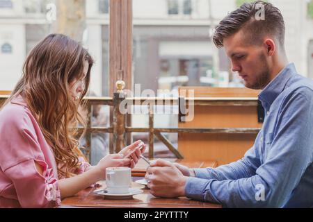 internet addiction, young couple reading social media on their smart phones, phubbing Stock Photo