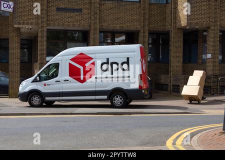 DPD delivery van parked on pavement with driver carrying boxes, ashford, kent, uk Stock Photo