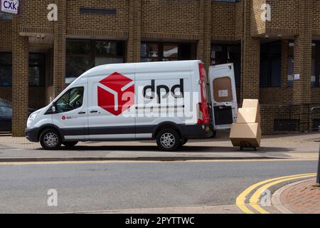 DPD delivery van parked on pavement with driver carrying boxes, ashford, kent, uk Stock Photo