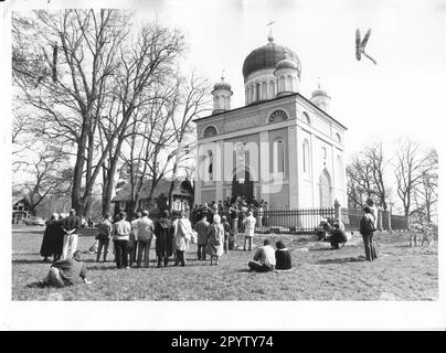 People singing spring songs in front of the Russian Orthodox Alexander Nevsky Memorial Church. Belongs to the Russian colony Alexandrovka. Historical buildings. Church. Chapel, Nauen suburb. Turning point. Turning point. Photo: Joachim Liebe, 09.04.1991 [automated translation] Stock Photo