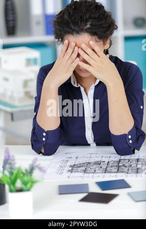 worried architect analyzing blueprints Stock Photo