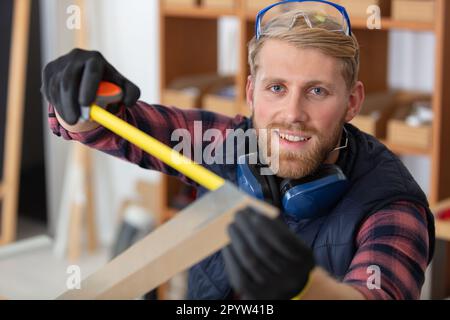 construction worker using measuring tape Stock Photo