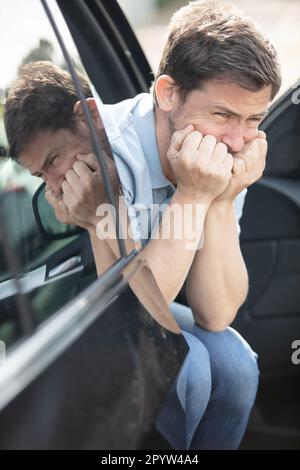portrait of stressed man sitting on car drivers seat Stock Photo