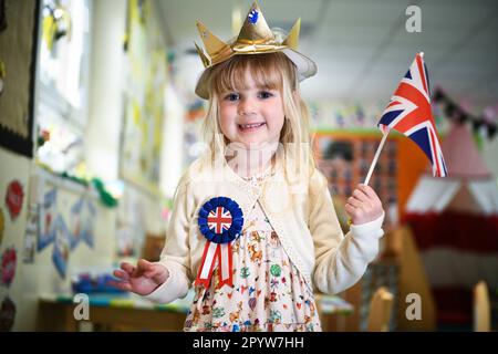 Pictured is a pupil from Waunarlwydd Primary School in Swansea, dressed-up to celebrate the Coronation of His Majesty The King on Saturday as members of the public across the UK get ready for the historical event which will see the crowning of King Charles. Pupils at the school were given the chance to wear red, white and blue for their school uniform and took part in coronation events through-out the day. Stock Photo