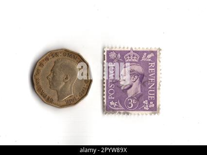 Threepenny bit and stamp from the reign of King George VI isolated on a white background. Stock Photo