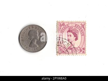 Sixpence coin and stamp from the reign of Queen Elizabeth II isolated on a white background. Stock Photo