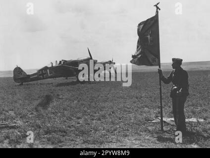 German Focke Wulf 190 on a field airfield, probably in Germany in the Reichsverteidigung. On the right a soldier with the unit's troop flag. PK photo: Speck. [automated translation] Stock Photo