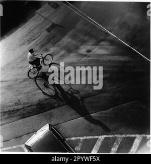 Transport, bike. Cyclists in Erlangen (Germany). Top view of the road with cyclist and his shadow. Street scene, black and white, 6x6 cm negative. Photo, 1992. Stock Photo