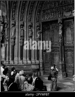 Freiburg in Breisgau. Munster of Our Lady. Tour group in front of the portal with carvings. Street scene, black and white. Photo, 1995. Stock Photo