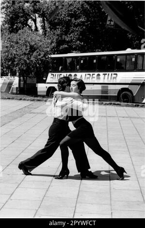 Buenos Aires, Argentina. Music, ballroom dancing, street dance: Tango. Dancing couple dances tango on the street as a show for tourists. Street scene, black and white. Photo, 1997. Stock Photo