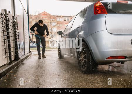 Car washing. Cleaning car using high pressure water. Stock Photo