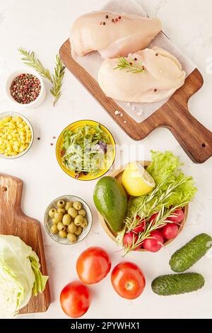 Aesthetics vegetables, fruits, chicken fillet, olives and greens top view. Keto, Paleo, Low carb, FODMAP diet concept. Stock Photo