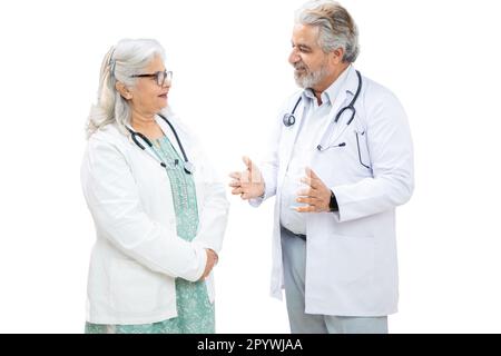 Senior Indian male and female doctor discussing isolated over white background, healthcare concept. Stock Photo