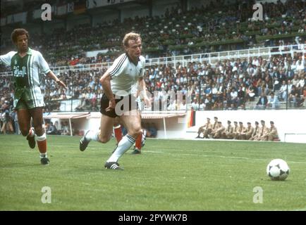 Soccer World Cup 1982 in Spain. Preliminary round: Algeria - Germany 2:1 / 16.06.1982 in Gijon. / Hans-Peter Briegel (GER) action in front of Lakhdar Belloumi (left). [automated translation] Stock Photo