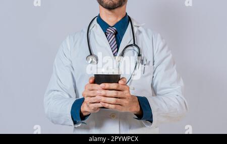 Young doctor holding a coffee to go isolated. Doctor hands holding paper coffee. Doctor holding takeaway coffee on isolated background Stock Photo