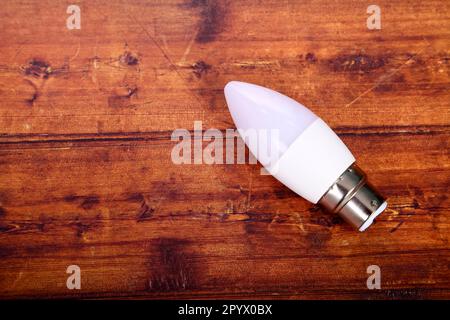 Low energy LED lightbulb laid on a wooden table with copy space Stock Photo