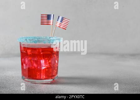 Patriotic red pomegranate margarita cocktail on gray background. Festive beverage for American Independence Day. Close up. Copy space. Rimmed drinks. Stock Photo