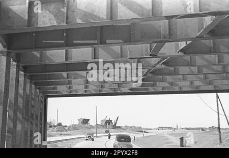 Transit under a bridge. In the background, ongoing construction work. Stock Photo