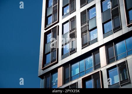 facade of a modern contemporary buiding, close up against a blue sky. Stock Photo