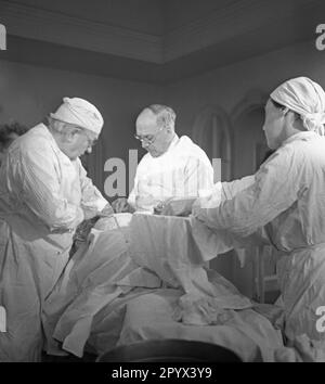 Professor Ferdinand Sauerbruch (center) and Julius Jungbluth (left) during a surgery at their private clinic in Berlin-Grunewald. Stock Photo